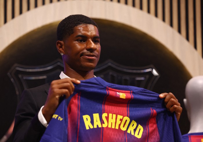Soccer Football - FC Barcelona present new player Marcus Rashford - FC Barcelona Club Shop, Barcelona, Spain - July 23, 2025 Barcelonas new signing Marcus Rashford poses with his shirt during the presentation REUTERS/Albert Gea