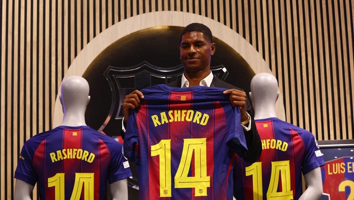 Soccer Football - FC Barcelona present new player Marcus Rashford - FC Barcelona Club Shop, Barcelona, Spain - July 23, 2025 Barcelonas new signing Marcus Rashford poses with his shirt during the presentation REUTERS/Albert Gea