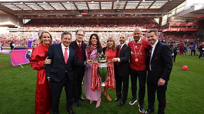 LIVERPOOL, ENGLAND - MAY 25: (L-R) Jennifer Ashton, Tom Werner, Chairman of Liverpool, and John Henry, Principle Owner of Liverpool, Linda Pizzuti Henry, Michael Gordon, President of Fenway Sports Group, Arne Slot, Manager of Liverpool and Billy Hogan, CEO of Liverpool pose for a photograph with the Premier League trophy, as Liverpool are crowned the Champions of the Premier League for the 2024/25 Season, following the Premier League match between Liverpool FC and Crystal Palace FC at Anfield on May 25, 2025 in Liverpool, England. (Photo by Liverpool FC/Liverpool FC via Getty Images)