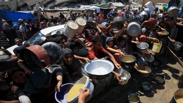 Palestinians gather to receive food from a charity kitchen, amid a hunger crisis, in Gaza City, July 25, 2025. REUTERS/Dawoud Abu Alkas