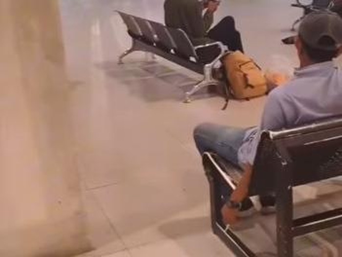 Tangkapan layar seorang lelaki bertopi merokok di area tidak boleh di pintu kemunculan Bandara Sultan Hasanuddin Makassar.