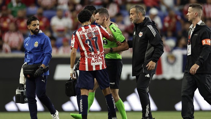 HARRISON, NEW JERSEY - JULY 31: Richard Ledezma #37 of Guadalajara consoles referee Lukasz Szpala who leaves the game injured during the Leagues Cup Phase One match between CD Guadalajara and New York Red Bulls at Sports Illustrated Stadium on July 31, 2025 in Harrison, New Jersey. (Photo by Adam Hunger - Leagues Cup/MLS via Getty Images)