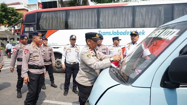 Satuan Brimob Polda Metro membagikan bendera Merah Putih di rumah warga jelang peringatan HUT ke-80 RI. (dok istimewa)