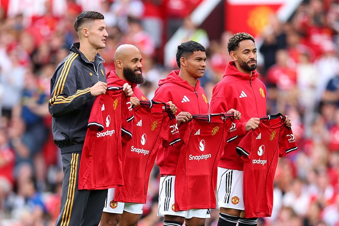 MANCHESTER, ENGLAND - AUGUST 09: New signings Bryan Mbeumo, Benjamin Sesko, Diego Leon and Matheus Cunha of Manchester United pose for a photo while holding match shirts prior to the pre-season friendly match between Manchester United and ACF Fiorentina at Old Trafford on August 09, 2025 in Manchester, England. (Photo by Molly Darlington/Getty Images)