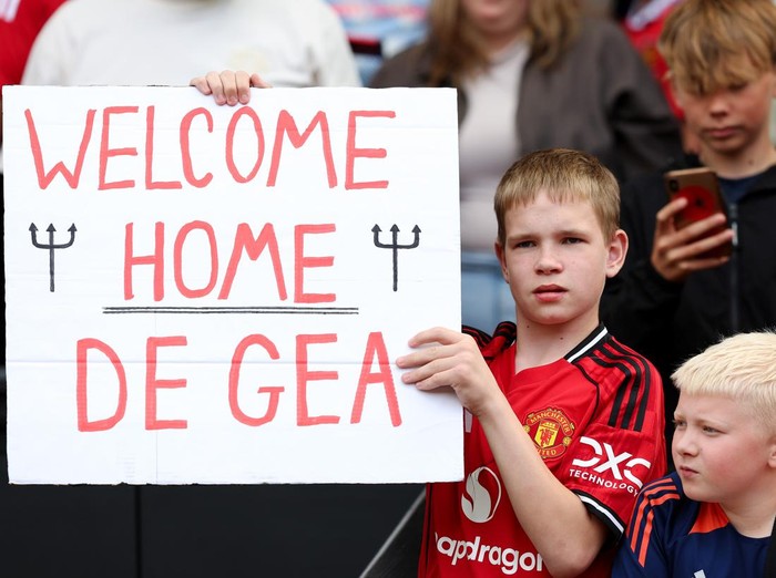MANCHESTER, ENGLAND - AUGUST 09: A young fan of Manchester United holds up a sign reading 'Welcome Home De Gea' during the pre-season friendly match between Manchester United and ACF Fiorentina at Old Trafford on August 09, 2025 in Manchester, England. (Photo by Matt McNulty/Getty Images)
