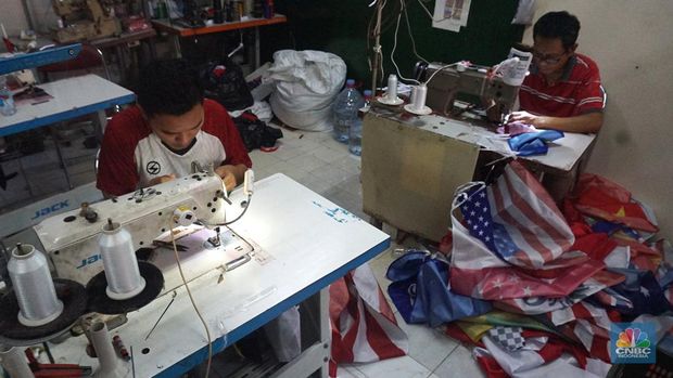 Pekerja melipat bendera di upaya konveksi rumahan nan memproduksi bendera umbul-umbul merah putih, topi, hingga kaos di area Tangerang Selatan, Banten, Senin (11/8/2025). (CNBC Indonesia/Muhammad Sabki)