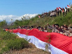 Polres Bima Bentangkan Bendera Merah Putih Raksasa di Bukit Dorobelo