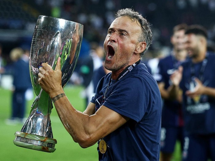 Soccer Football - UEFA Super Cup - Final - Paris St Germain v Tottenham Hotspur - Bluenergy Stadium, Udine, Italy - August 13, 2025 Paris St Germain coach Luis Enrique celebrates with the trophy after winning the UEFA Super Cup REUTERS/Guglielmo Mangiapane