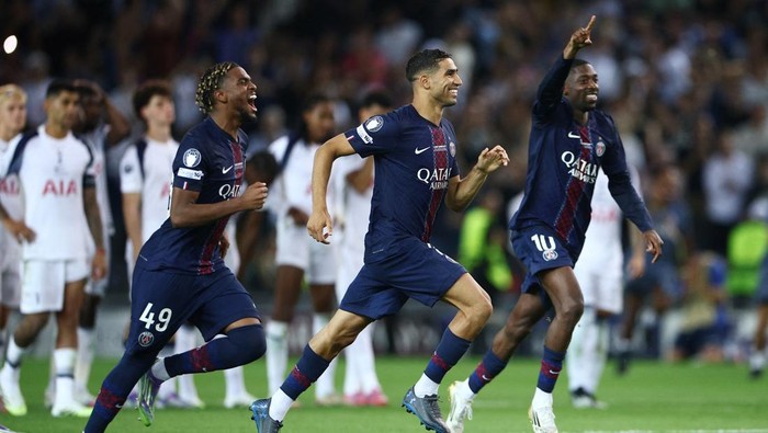 Soccer Football - UEFA Super Cup - Final - Paris St Germain v Tottenham Hotspur - Bluenergy Stadium, Udine, Italy - August 13, 2025 Paris Saint Germains Noham Kamara, Ousmane Dembele and Achraf Hakimi celebrate after winning the UEFA Super Cup REUTERS/Guglielmo Mangiapane