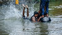Jatuh Bangun, Peserta Akhirnya Taklukkan Pinang di Tengah Sungai Bekasi