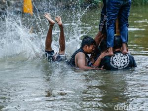 Jatuh Bangun, Peserta Akhirnya Taklukkan Pinang di Tengah Sungai Bekasi