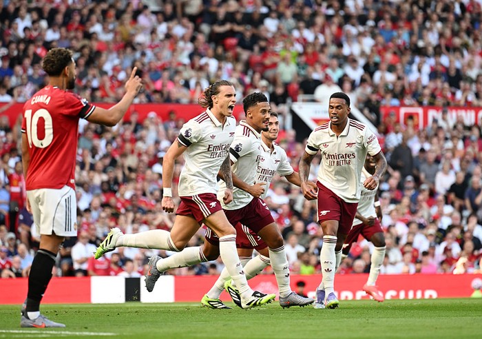 MANCHESTER, ENGLAND - AUGUST 17: Riccardo Calafiori of Arsenal celebrates scoring his team's first goal with William Saliba and Gabriel of Arsenal during the Premier League match between Manchester United and Arsenal at Old Trafford on August 17, 2025 in Manchester, England. (Photo by Stuart MacFarlane/Arsenal FC via Getty Images)