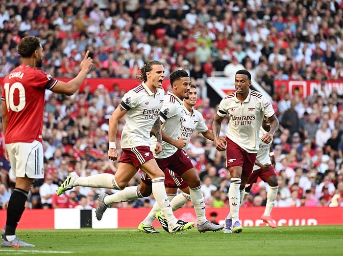 MANCHESTER, ENGLAND - AUGUST 17: Riccardo Calafiori of Arsenal celebrates scoring his team's first goal with William Saliba and Gabriel of Arsenal during the Premier League match between Manchester United and Arsenal at Old Trafford on August 17, 2025 in Manchester, England. (Photo by Stuart MacFarlane/Arsenal FC via Getty Images)
