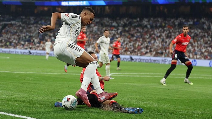 MADRID, SPAIN - AUGUST 19: Kylian Mbappé of Real Madrid is challenged by 
Juan Cruz of Osasuna during the LaLiga EA Sports match between Real Madrid CF and CA Osasuna at Estadio Santiago Bernabeu on August 19, 2025 in Madrid, Spain. (Photo by Florencia Tan Jun/Getty Images)