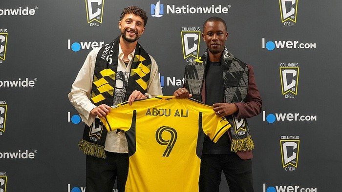 COLUMBUS, OHIO - AUGUST 19: Forward Wessam Abou Ali #9 of the Columbus Crew and Columbus Crew General Manager Issa Tall pose for a photo with his jersey during a introductory held at Lower.com Field on August 19, 2025 in Columbus, Ohio. (Photo by Jason Mowry/Getty Images)