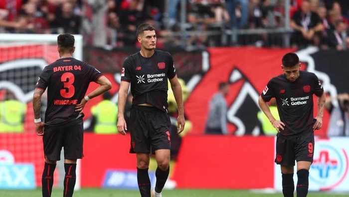 Soccer Football - Bundesliga - Bayer Leverkusen v TSG 1899 Hoffenheim - BayArena, Leverkusen, Germany - August 23, 2025  Bayer Leverkusens Piero Hincapie, Bayer Leverkusens Claudio Echeverri and Bayer Leverkusens Patrik Schick look dejected after the match REUTERS/Leon Kuegeler DFL REGULATIONS PROHIBIT ANY USE OF PHOTOGRAPHS AS IMAGE SEQUENCES AND/OR QUASI-VIDEO.