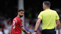 Terlihat Fernandes menatap tajam wasit. Usai laga, gelandang asal Portugal itu mengaku kesal karena sempat disenggol Kavanagh, yang mengaku konsentrasinya jadi rusak. (Foto: Marc Atkins/Getty Images)