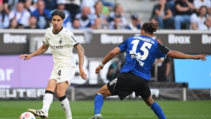 MOENCHENGLADBACH, GERMANY - AUGUST 24: Kevin Diks of Borussia Monchengladbach is challenged by Yussuf Poulsen of Hamburger SV during the Bundesliga match between Borussia Mönchengladbach and Hamburger SV at Borussia-Park on August 24, 2025 in Moenchengladbach, Germany. (Photo by Frederic Scheidemann/Getty Images)