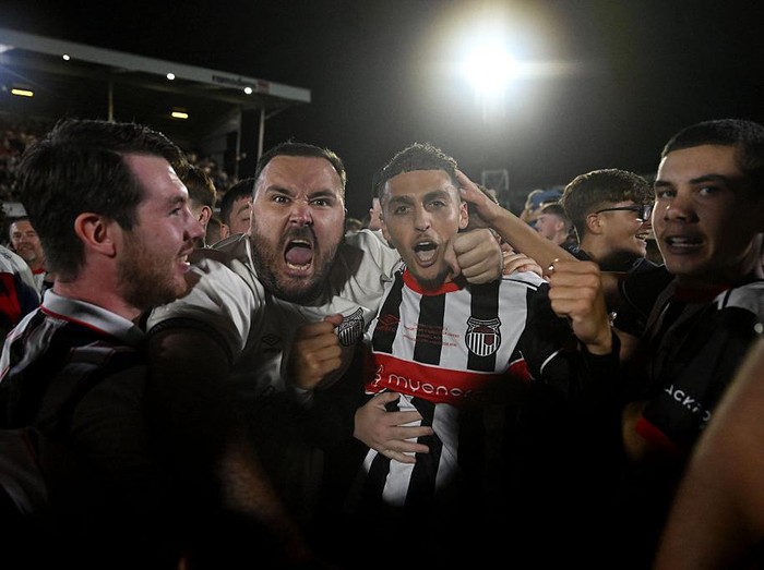 GRIMSBY, ENGLAND - AUGUST 27: Jaze Kabia of Grimsby Town celebrates victory with fans as they storm the pitch following the penalty shoot out during the Carabao Cup Second Round match between Grimsby Town and Manchester United at Blundell Park on August 27, 2025 in Grimsby, England.  (Photo by Shaun Botterill/Getty Images)