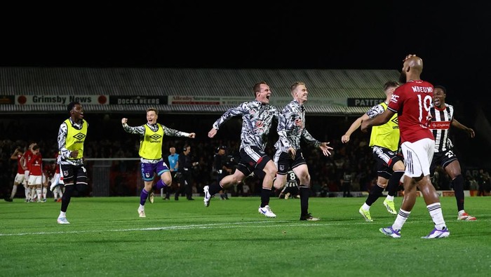 Soccer Football - Carabao Cup - Second Round - Grimsby Town v Manchester United - Blundell Park, Grimsby, Britain - August 27, 2025 Manchester Uniteds Bryan Mbeumo looks dejected after he misses a penalty as Grimsby Town players celebrate after winning the shoot-out Action Images via Reuters/Lee Smith EDITORIAL USE ONLY. NO USE WITH UNAUTHORIZED AUDIO, VIDEO, DATA, FIXTURE LISTS, CLUB/LEAGUE LOGOS OR LIVE SERVICES. ONLINE IN-MATCH USE LIMITED TO 120 IMAGES, NO VIDEO EMULATION. NO USE IN BETTING, GAMES OR SINGLE CLUB/LEAGUE/PLAYER PUBLICATIONS. PLEASE CONTACT YOUR ACCOUNT REPRESENTATIVE FOR FURTHER DETAILS..