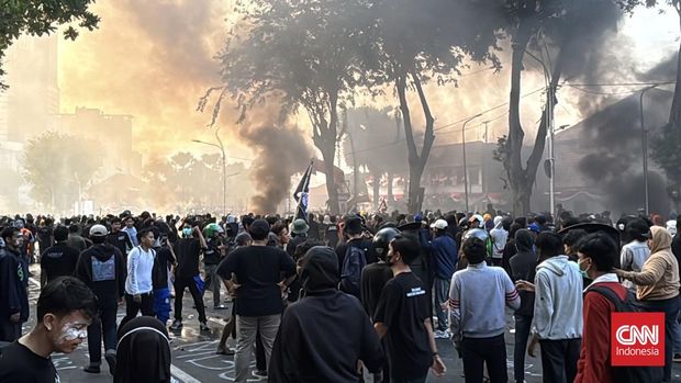 Aparat kepolisian menembakkan senjata gas air mata ke arah massa aksi solidaritas Affan Kurniawan, di depan Gedung Negara Grahadi, Surabaya, Jawa Timur, Jumat (29/8). Bentorokan terjadi, massa secara terus menerus melempar benda ke arah aparat kepolisian yang berjaga sisi dalam gerbang. Mulai batu, kayu, hingga petasan.