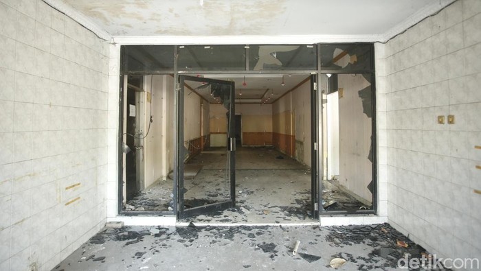 Markas Gegana di Jalan Kramat Raya hancur diamuk massa. Dua bus hangus masih terparkir di depan, sementara warga berkerumun menyaksikan kondisi bangunan, Sabtu (30/8/2025).