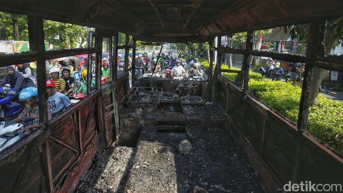 Markas Gegana di Jalan Kramat Raya hancur diamuk massa. Dua bus hangus masih terparkir di depan, sementara warga berkerumun menyaksikan kondisi bangunan, Sabtu (30/8/2025).