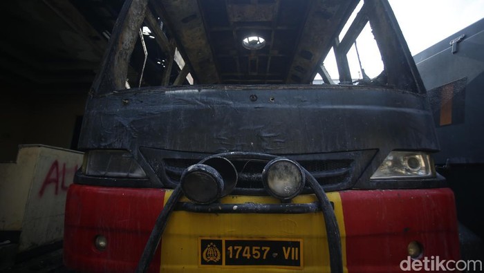 Markas Gegana di Jalan Kramat Raya hancur diamuk massa. Dua bus hangus masih terparkir di depan, sementara warga berkerumun menyaksikan kondisi bangunan, Sabtu (30/8/2025).