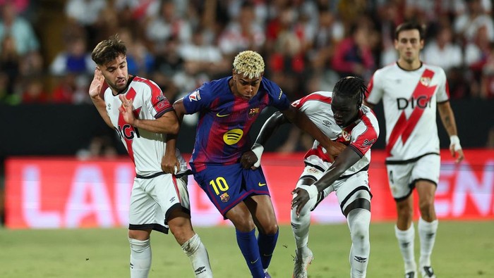 Soccer Football - LaLiga - Rayo Vallecano v FC Barcelona - Campo de Futbol de Vallecas, Madrid, Spain - August 31, 2025 FC Barcelonas Lamine Yamal in action with Rayo Vallecanos Pathe Ciss and Unai Lopez REUTERS/Isabel Infantes