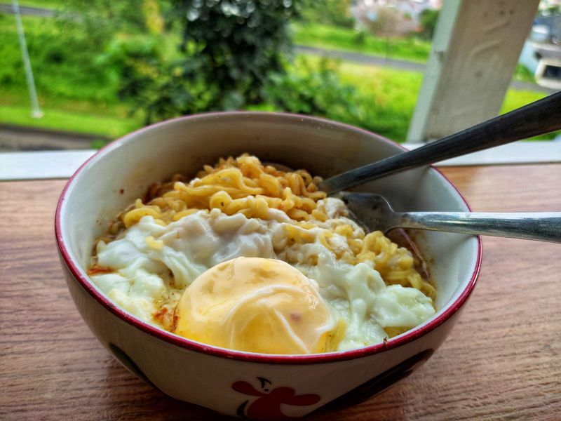 1467861270 noodle soup served in a bowl with complete toppings containing chicken eggs, with a background of elite housing and green hills