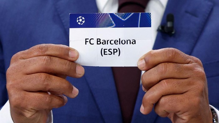Brazilian former football international Giovane Elber holds up the slip of FC Barcelona during the draw for the round of 16 of the 2024-2025 UEFA Champions League football tournament at the House of European Football in Nyon, on February 21, 2025. (Photo by Valentin Flauraud / AFP)
