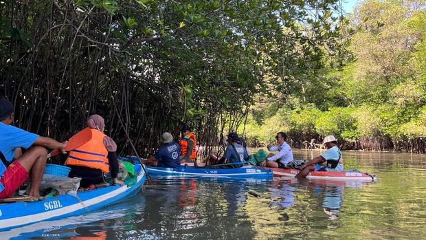 Para petugas gabungan saat membersihkan sampah di kawasan mangrove Denpasar, Bali, Sabtu (13/9).