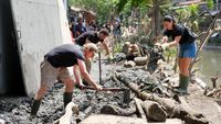 Potret WNA Ikut Gotong Royong Bersihkan Lumpur Pascabanjir di Bali