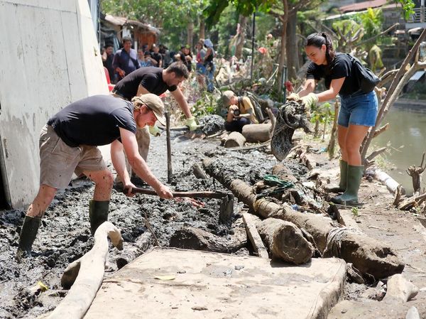 Potret WNA Ikut Gotong Royong Bersihkan Lumpur Pascabanjir di Bali