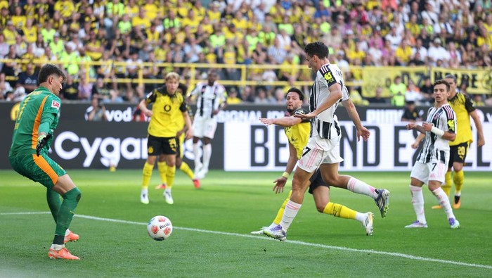 DORTMUND, GERMANY - AUGUST 10: Andrea Cambiaso of Juventus scores his teams first goal past Gregor Kobel of Borussia Dortmund during the pre-season friendly match between Borussia Dortmund and Juventus FC at Signal Iduna Park on August 10, 2025 in Dortmund, Germany. (Photo by Lars Baron/Getty Images)