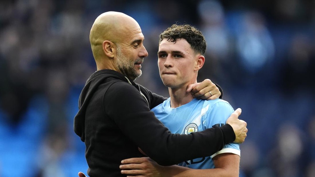Pep Guardiola memeluk Phil Foden usai City menang 3-0 atas MU. (Foto: Nick Potts/PA Images via Getty Images)