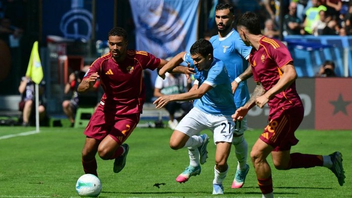 Romas Dutch defender #02 Devyne Rensch fights for the ball with Lazios Moroccan midfielder #21 Reda Belahyane during the Italian Serie A football match between Lazio and Roma at the Olympic stadium in Rome, on September 21, 2025. (Photo by Tiziana FABI / AFP)