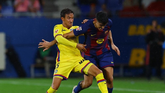 Soccer Football - LaLiga - FC Barcelona v Getafe - Johan Cruyff Stadium, Barcelona, Spain - September 21, 2025 Getafes Luis Milla in action with FC Barcelonas Gerard Martin REUTERS/Albert Gea