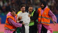 Suporter itu pun kemudian segera dibawa oleh petugas untuk meninggalkan lapangan agar laga Barca vs Getafe bisa lanjut. Di laga itu sendiri Barca menang 3-0. Foto: REUTERS/Albert Gea