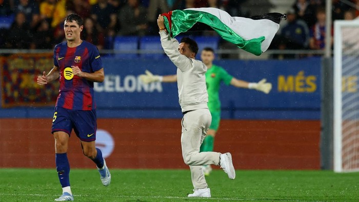 Soccer Football - LaLiga - FC Barcelona v Getafe - Johan Cruyff Stadium, Barcelona, Spain - September 21, 2025 General view of a pitch invader with a Palestine flag during the match as FC Barcelonas Andreas Christensen looks on REUTERS/Albert Gea