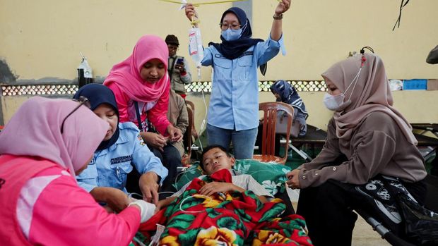 Naya Raisa Nuraini, 14, lies on a velbed while receiving treatments for food poisoning after eating government-sponsored free school meals, at a makeshift clinic inside a district's hall in Bandung, West Java province, Indonesia, September 25, 2025. REUTERS/Willy Kurniawan