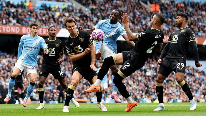MANCHESTER, ENGLAND - SEPTEMBER 27: Jeremy Doku of Manchester City is challenged by Hjalmar Ekdal and Kyle Walker of Burnley during the Premier League match between Manchester City and Burnley at Etihad Stadium on September 27, 2025 in Manchester, England. (Photo by Jan Kruger/Getty Images)
