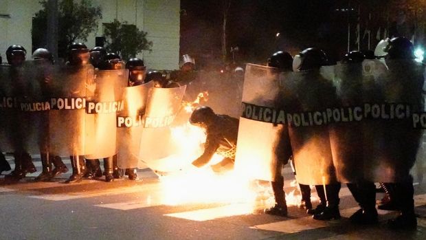 A Molotov cocktail falls on a police officer during a demonstration organised by a youth collective called 