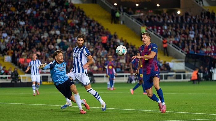 BARCELONA, SPAIN - SEPTEMBER 28: Robert Lewandowski of FC Barcelona competes for the ball with Alex Remiro of Real Sociedad during the LaLiga EA Sports match between FC Barcelona and Real Sociedad at Estadi Olimpic Lluis Companys on September 28, 2025 in Barcelona, Spain. (Photo by Pedro Salado/Getty Images)