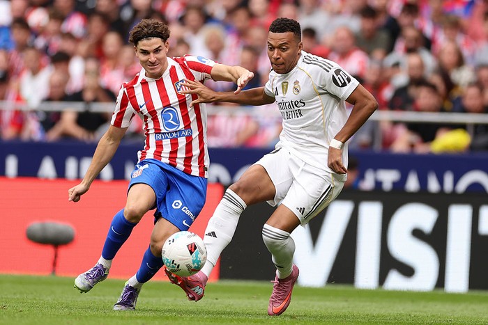 Kylian Mbappe of Real Madrid completes for the ball with Julian Alvarez of Atletico Madrid during the LaLiga EA Sports match between Atletico Madrid and Real Madrid