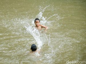 Potret Anak-anak Asyik Berenang di Kalimalang Saat Hujan