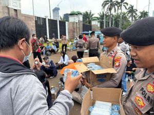 Aksi Polisi Bagi-bagi Air Mineral dan Roti ke Massa Buruh di DPR