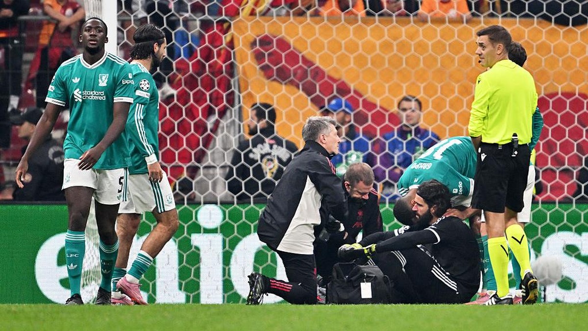 Alisson (duduk) saat mendapat perawatan di tengah laga melawan Galatasaray. Foto: Liverpool FC via Getty Images/Liverpool FC