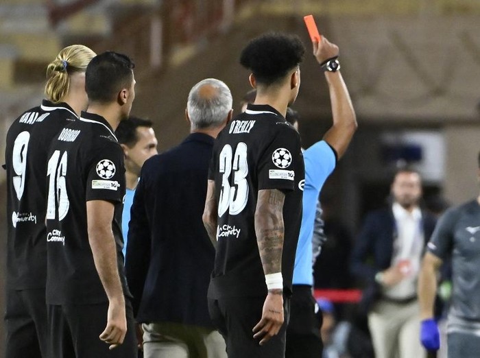 Spanish referee Jesus Gil Manzano holds a red card (C) during the UEFA Champions League, league phase day 2, football match between Monaco and Manchester City at Stade Louis II, in Monaco on October 1, 2025. (Photo by FREDERIC DIDES / AFP)