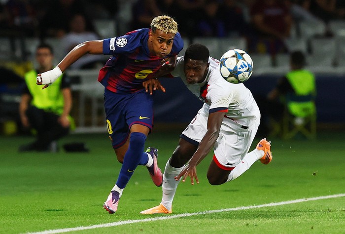 Soccer Football - UEFA Champions League - FC Barcelona v Paris St Germain - Estadi Olimpic Lluis Companys, Barcelona, Spain - October 1, 2025 FC Barcelonas Lamine Yamal in action with Paris St Germains Nuno Mendes REUTERS/Albert Gea